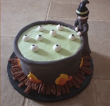 A Halloween cake modelled as a witch’s cauldron with sugar eyeballs and a log fire